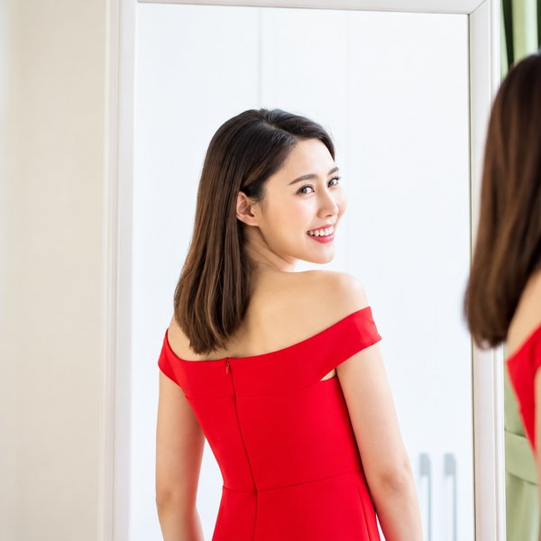 鏡の前でドレスを着て微笑む女性