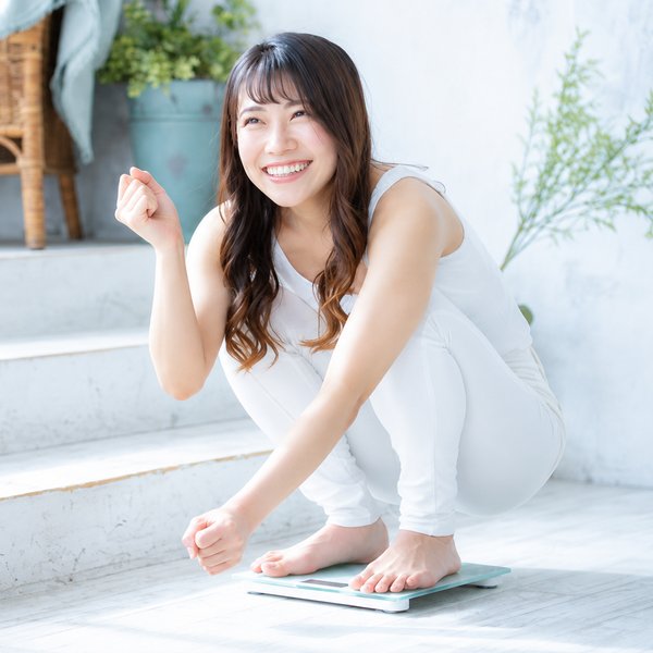 体重計の上で喜ぶ女性